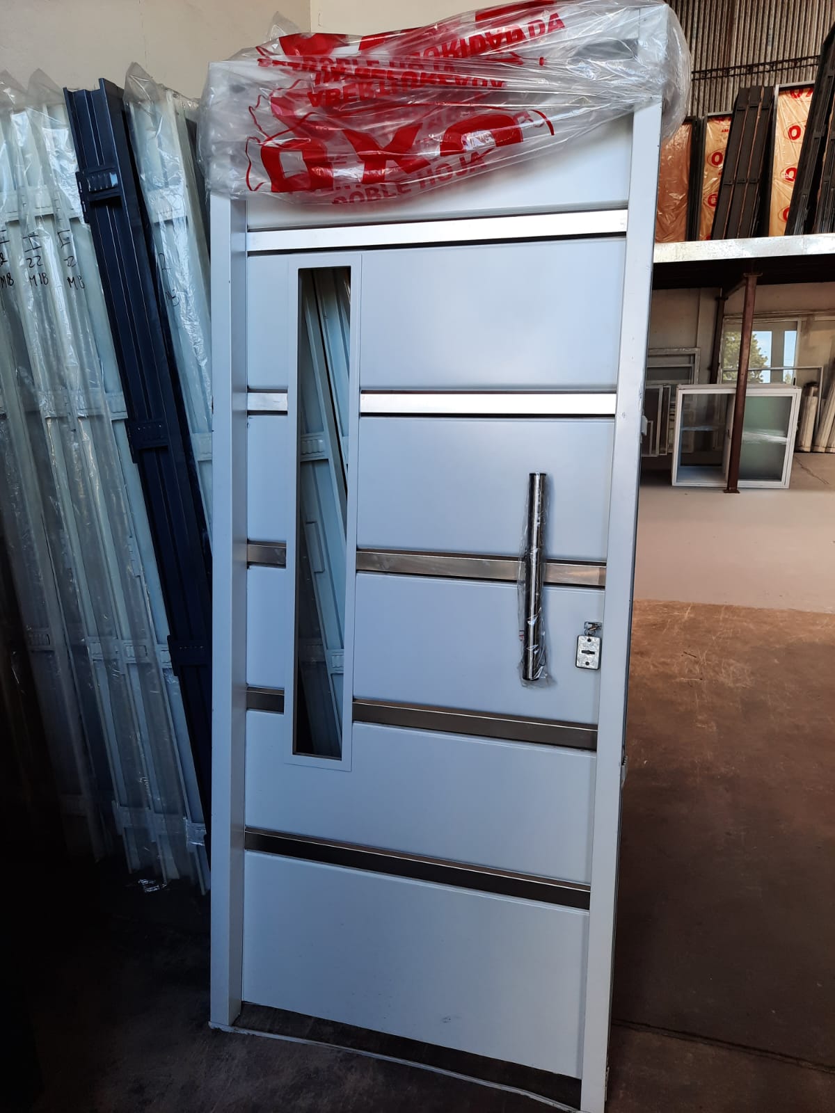 Puerta doble hoja blanca con bandas inox en fábrica