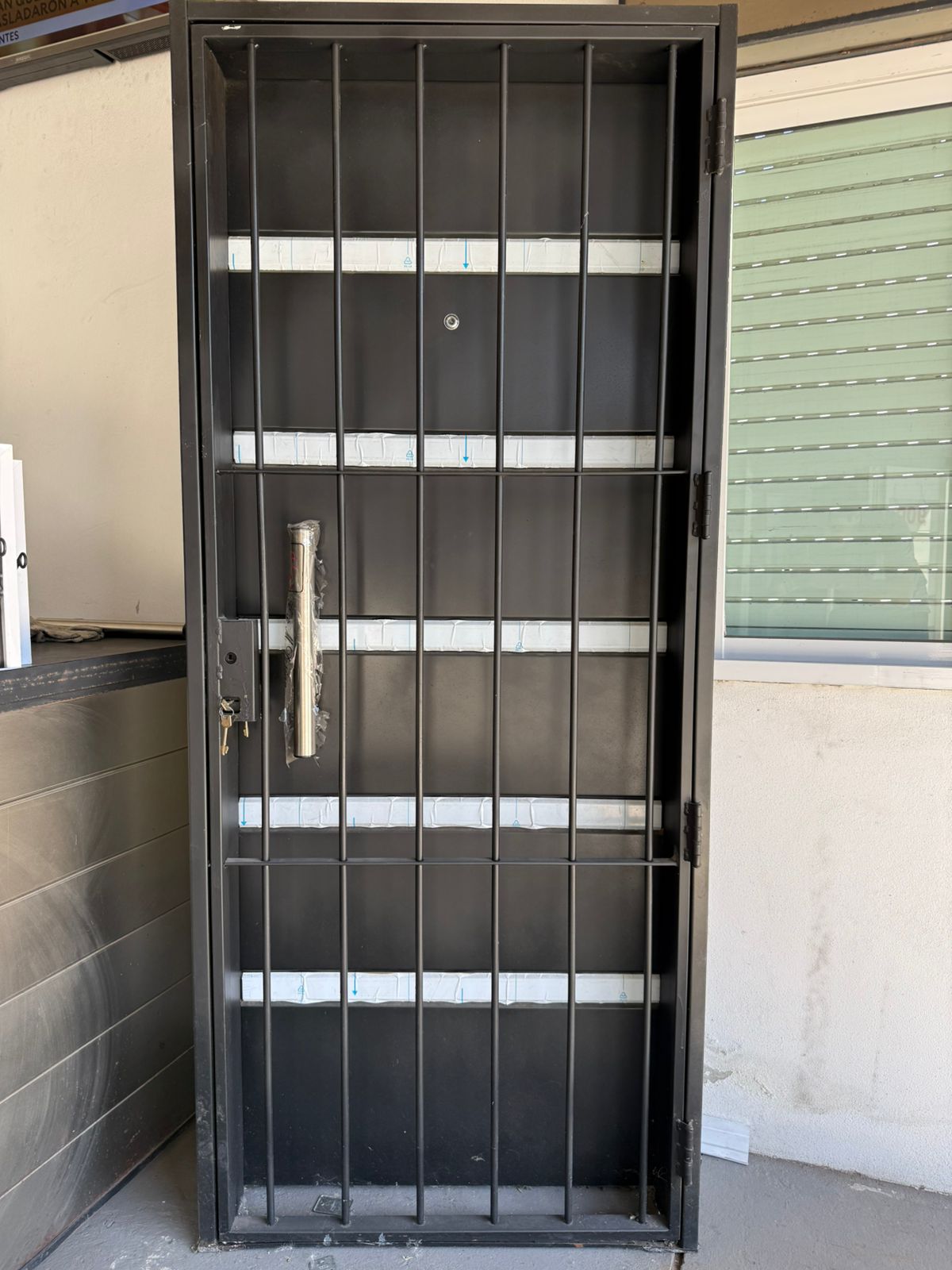 Puerta doble hoja negra con barrotes verticales y horizontales