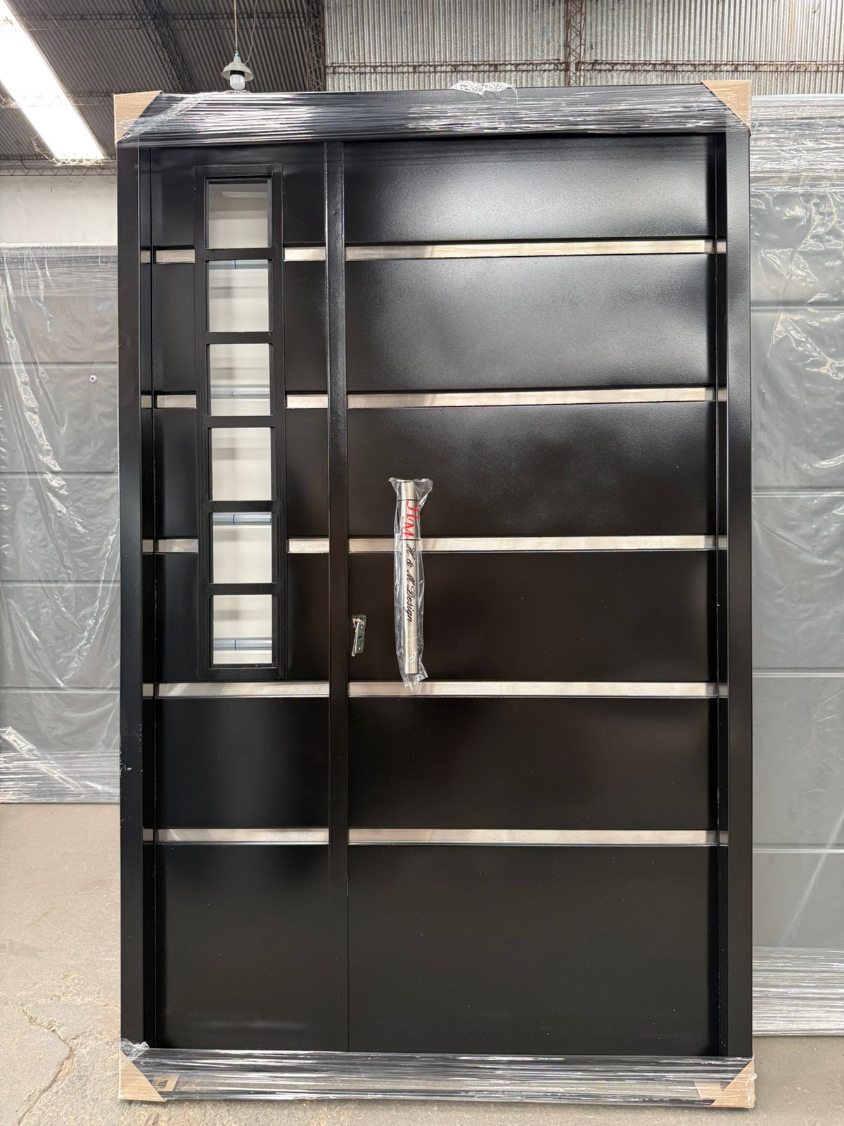 Portal doble hoja negro con vidrio lateral en fábrica